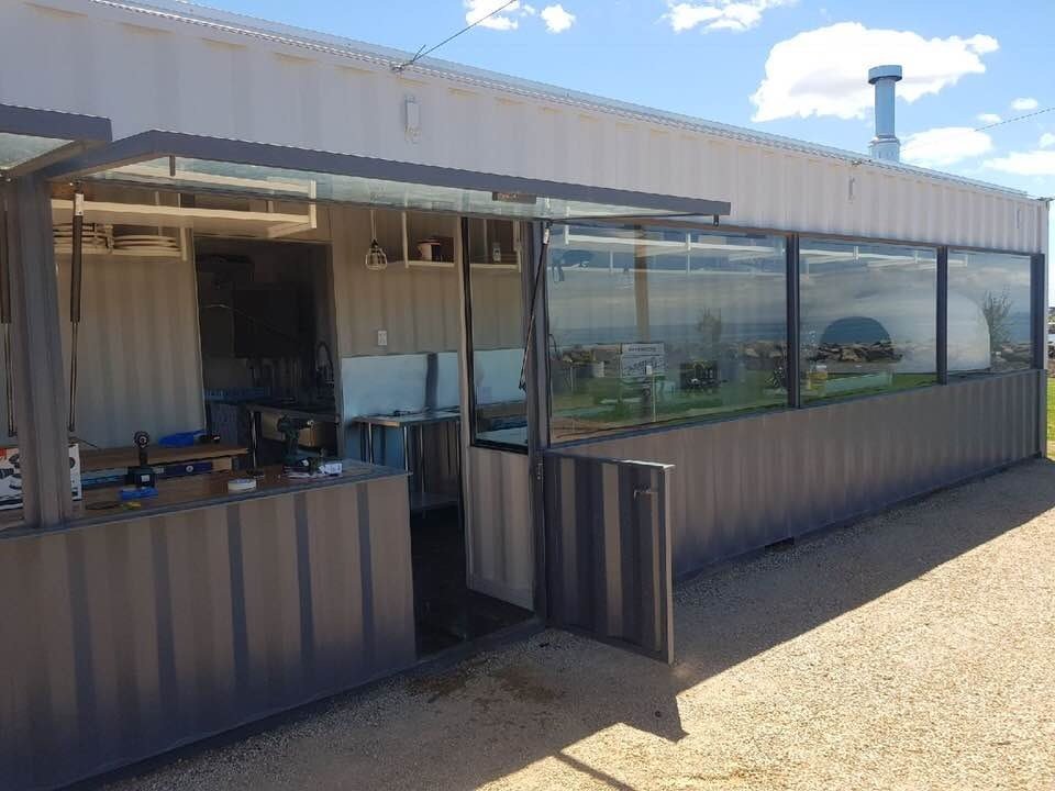 Container café exterior showing an open serving hatch and glazed frontage