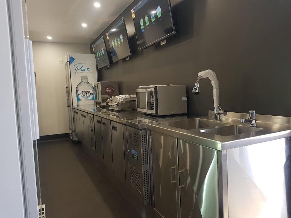 Completed commercial café interior with stainless-steel benches, sinks and refrigeration