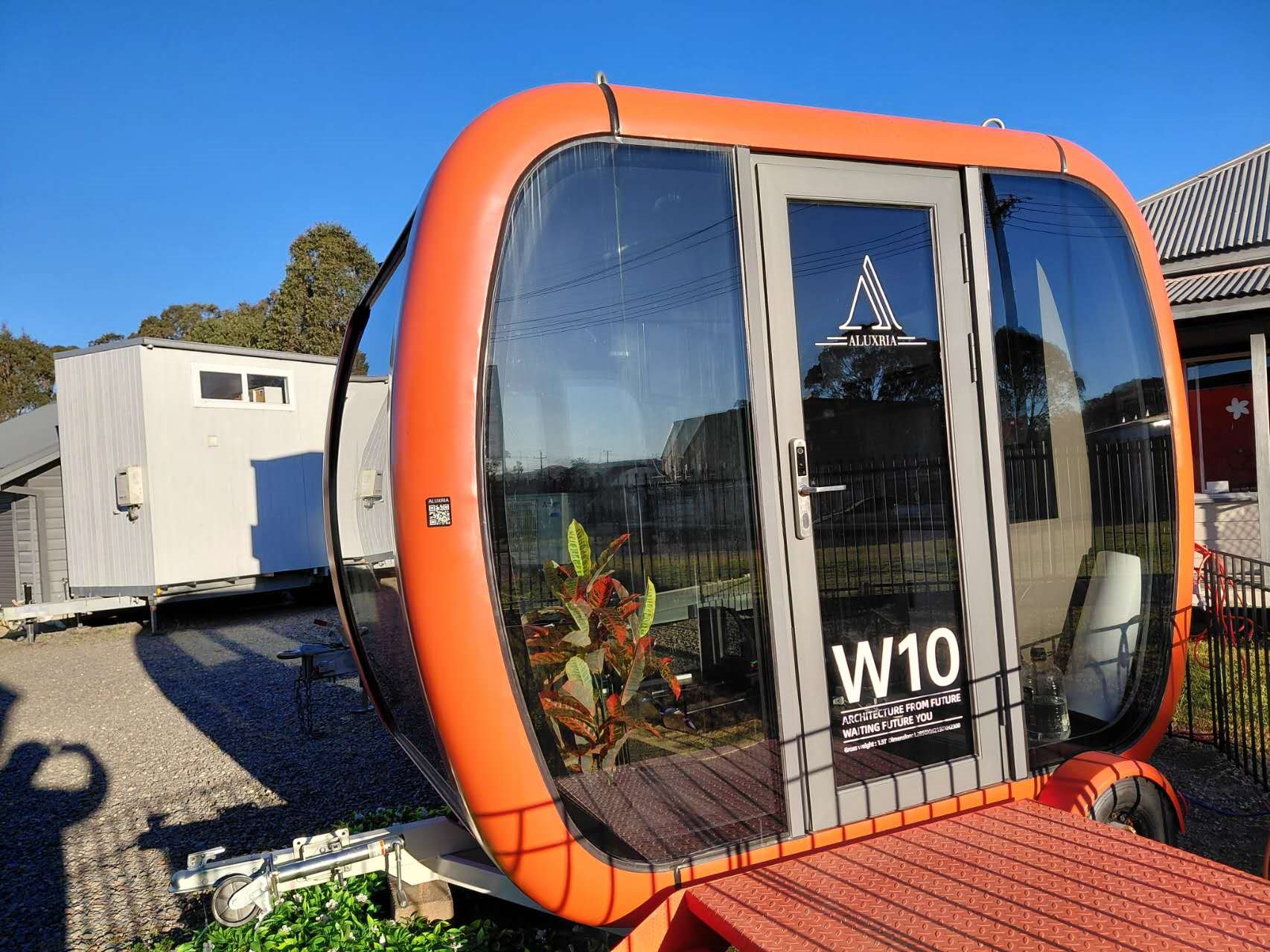Compact orange mobile pod on a trailer chassis