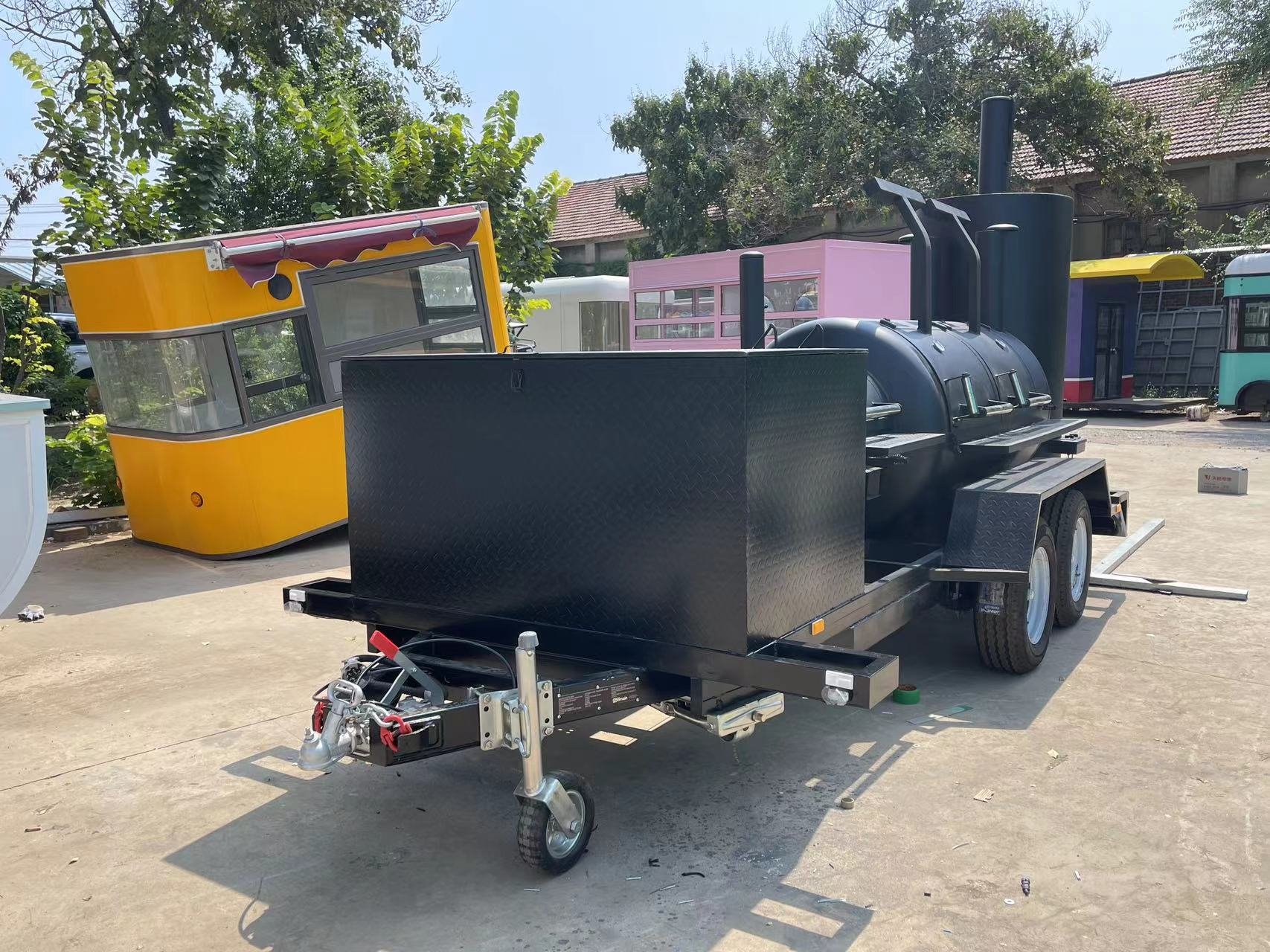 Custom black smoker trailer with three cooking chambers